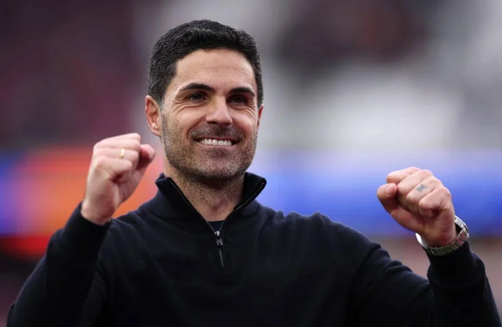 A smiling Mikel Arteta punches the air in delight