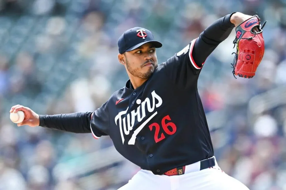 Minnesota Twins pitcher Taj Bradley cocks back his right arm as he prepares to deliver a pitch during an MLB game.